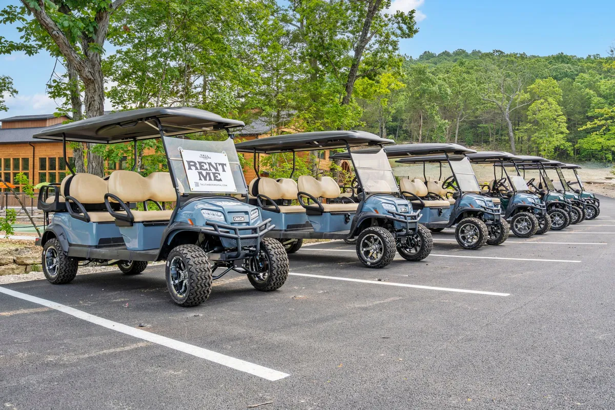A set of golf carts is parked beside a 'for rent' sign amidst natural surroundings, suggesting easy exploration of the expansive, still-growing property. The landscape around the carts remains open and ripe for discovery.