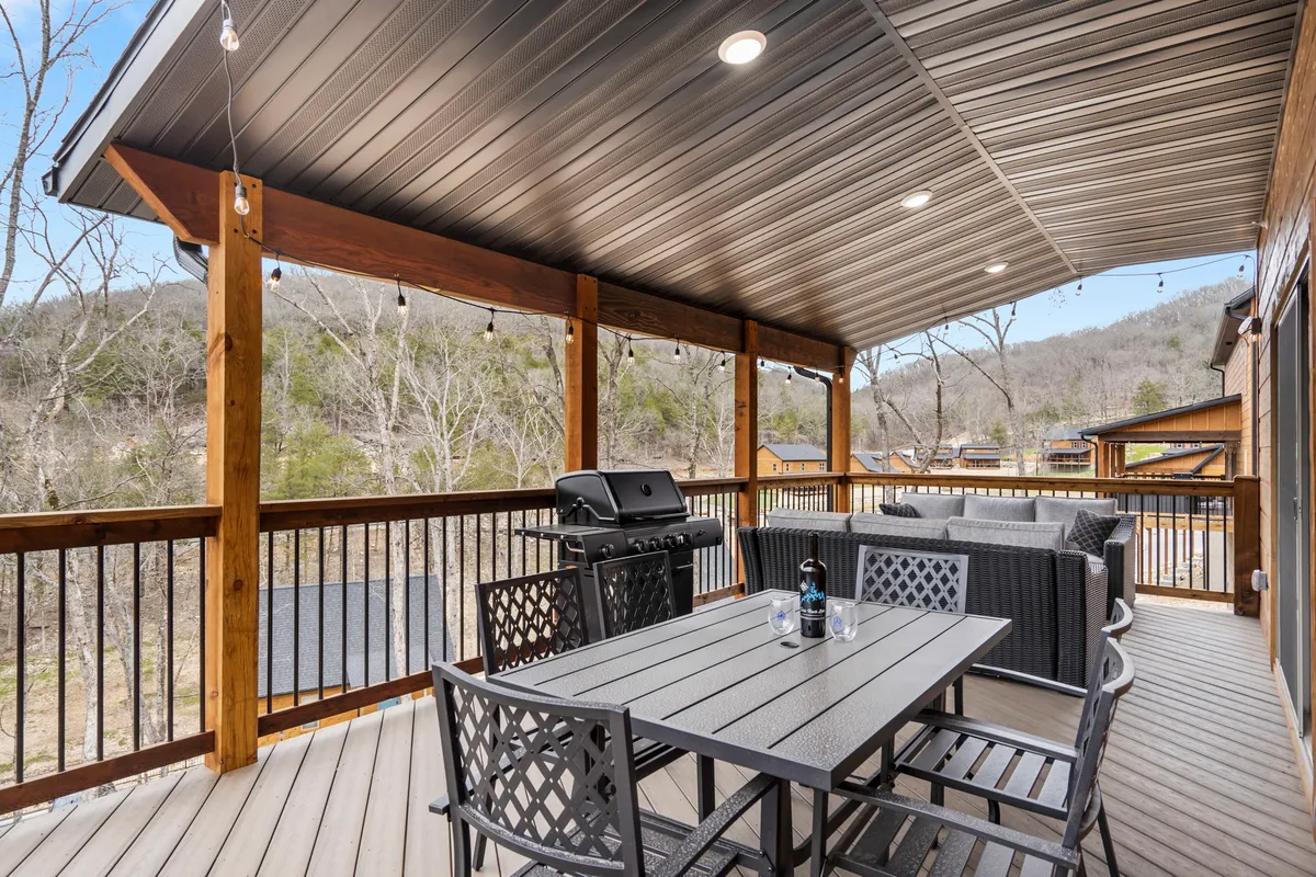 A wooden deck set against a backdrop of hills and mature trees, offering a peaceful spot for outdoor dining or simply taking in the surrounding landscape. The space is ideal for sunset gatherings or quiet moments spent watching wildlife.
