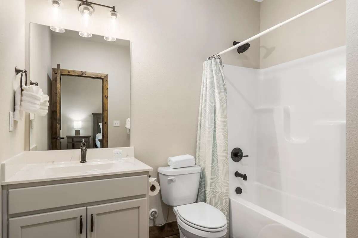 A modern bathroom with a vanity and sink, mirror, walk-in shower, and toilet. The space is serene and inviting—perfect for unwinding and morning routines.